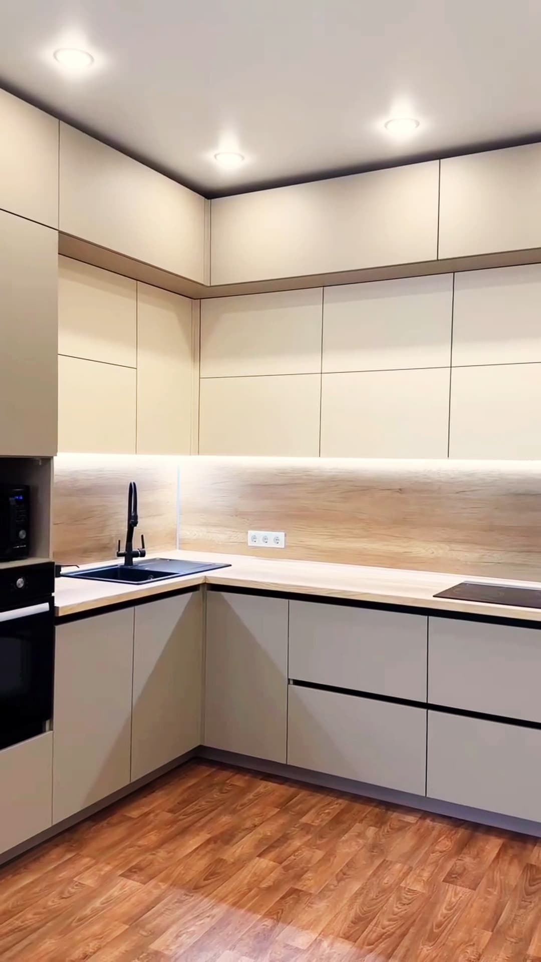 Cuisine en L crème et bois avec éclairage sous meubles hauts, réalisée par ArtMood à Tanger